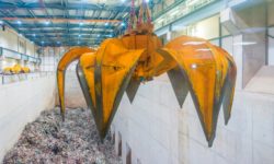 A grabber hanging over a pit of general waste