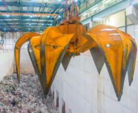 A grabber hanging over a pit of general waste