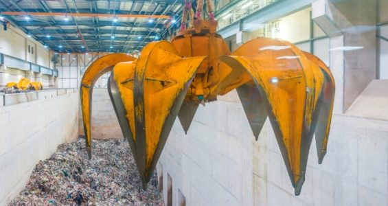 A grabber hanging over a pit of general waste