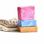 Natural sponge and three bars of soaps stacked