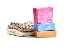 Natural sponge and three bars of soaps stacked