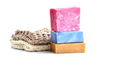 Natural sponge and three bars of soaps stacked