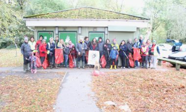 Group of people with litter picks and bags in a park