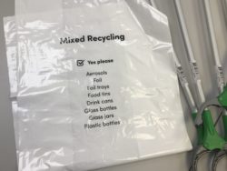 white bag for collecting mixed recycling items and three litter pickers