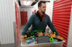 Man holding box full of childrens' toys