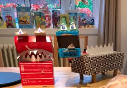Two junk model monsters made out of cardboard boxes and recycled materials