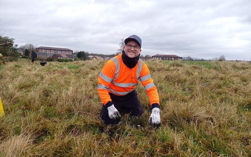 Man in high visibility jacket planting trees