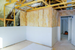 Installing plasterboard sheet to wall for attic room construction at the attic thermal insulation