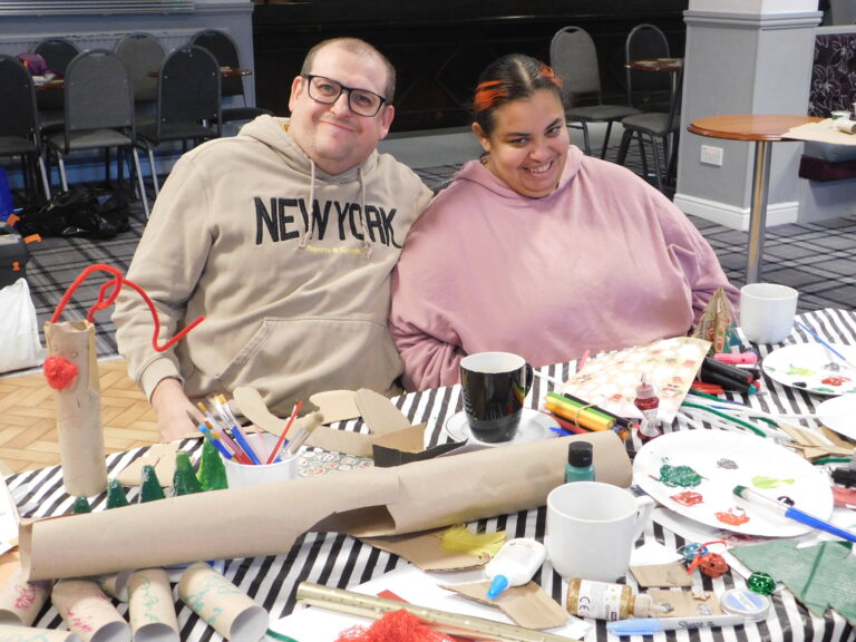 two people in front of a a crafting table