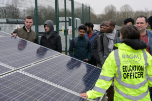 Education officer talking to a group of people at a solar farm