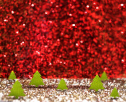 image of red glitter background with paper mini Christmas trees
